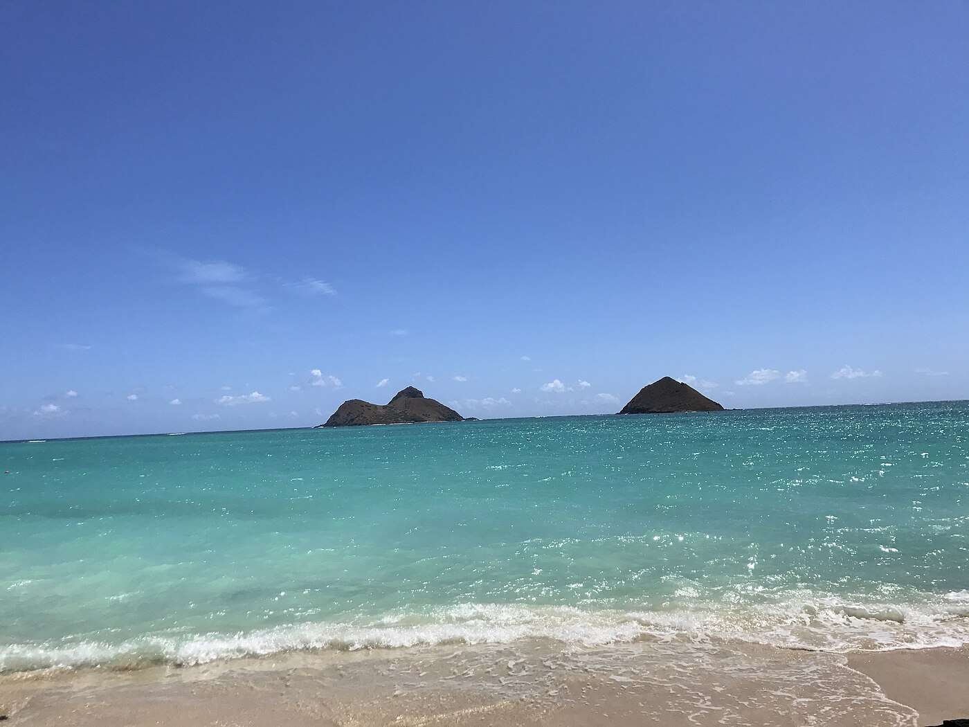 Turquoise water and the twin Mokulua islets offshore from the sand at Lanikai Beach